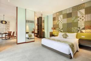 a bedroom with a large bed and a dining room at The Elysian Boutique Villa Hotel in Seminyak