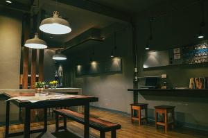 a room with a table and benches and a bar at Yaksa Private in Bangkok
