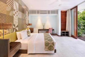a bedroom with a bed and a desk at The Elysian Boutique Villa Hotel in Seminyak