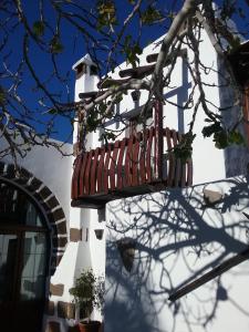 a white lighthouse with a bench in front of a building at Casa Rural "La Molina" in Máguez