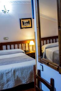 a bedroom with two beds and a mirror at Hotel Los Angeles in Santillana del Mar +81 photos