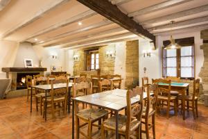 a dining room with tables and chairs and a fireplace at Posada de Uncastillo in Uncastillo