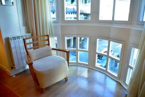 una silla en una habitación con ventanas en Hotel Palacete en Hondarribia