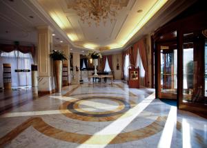 a lobby with a large rug on the floor at Grand Visconti Palace in Milan