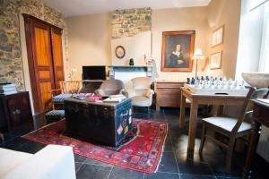 um quarto com uma sala de estar com uma mesa e uma sala de estar em B&B Le Vieux Marronnier em Foy-Notre-Dame