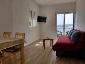 a living room with a couch and a table and a window at Villa Marina in Omiš