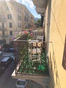 uma varanda com mesa, cadeiras e flores em Tino'S House em La Spezia