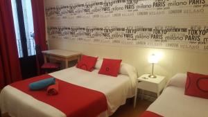 Pokój hotelowy z 2 łóżkami z czerwonymi i niebieskimi poduszkami w obiekcie Pension Aries w mieście San Sebastián +17 zdjęć