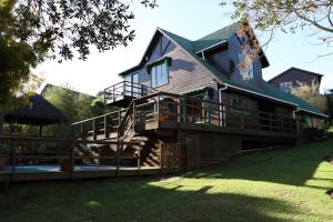 a large wooden house with a large deck at Allan Grove 2 in Knysna