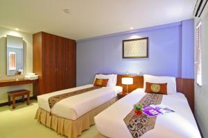 two beds in a hotel room with purple walls at Floral Shire Suvarnabhumi Airport in Lat Krabang +83 photos