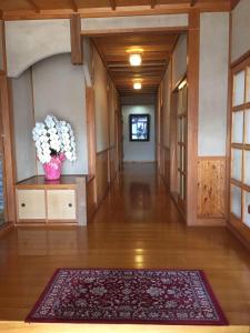 a hallway with a vase of flowers in a room at Guest house En in Fujiyoshida
