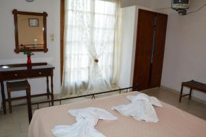 a bedroom with a bed and a dresser at Voula Apartments in Agia Marina Aegina