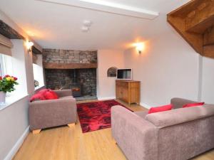 a living room with two couches and a fireplace at Red Rose Cottage in Cheddar