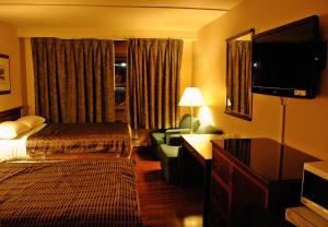 a hotel room with a bed and a television at Chomedey Inn in Laval +17 photos