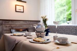una mesa con un plato de comida y una copa de vino en Hotel Hinrichs, en Carolinensiel