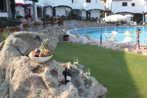 a bowl of fruit on a rock next to a pool at Hotel Resort Nuraghe Arvu in Cala Gonone