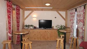 Habitación con taburetes y TV de pantalla plana. en Alpen Roc en Morzine
