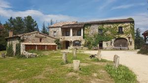 una vieja casa de piedra con un perro delante de ella en Suite Cardinale 40m2 chambre d' hôte du Mas Fabrègue, en Servas