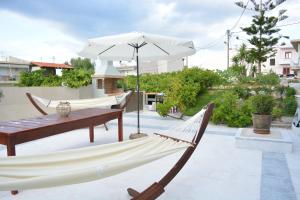 a hammock and an umbrella on a patio at Thegaia Studios in Rethymno