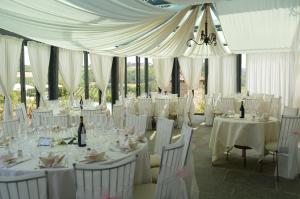 una habitación llena de mesas y sillas con mantel blanco en Agriturismo La Torricella, en Monforte dʼAlba
