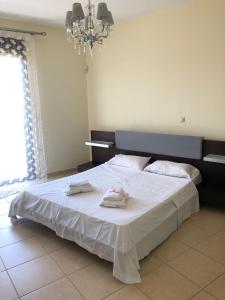 a bedroom with a large bed with two towels on it at Villa Evi in Ixia
