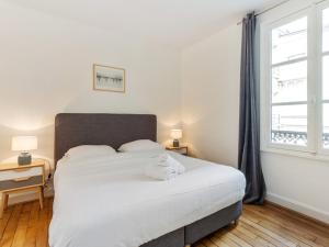 パリにあるWelkeys - St Honoreのベッドルーム(大きな白いベッド1台、窓付)