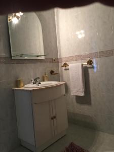 a bathroom with a sink and a mirror at Casa do gato branco in Furadouro +46 photos