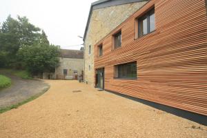 a building with a wooden wall on the side of it at Gite MontBleu - 2 holiday houses - La Laiterie & La Grange in Sprimont