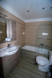 a bathroom with a sink and a tub and a toilet at Kordistos Hotel in Kefalos