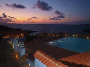 a view of a swimming pool at sunset at Giorgi's Blue Apartments in Kalathas