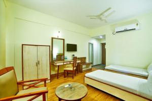 a hotel room with a bed and a desk and a table at Shanthiniketan - Ramoji Film City in Pedda Ambarpet