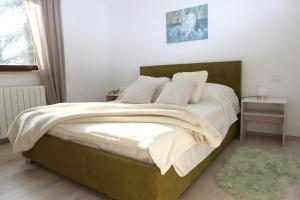 a bedroom with a large bed with a green headboard at Garden in Pula