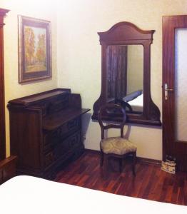 a bedroom with a dresser and a mirror and a chair at ELDA's Home - Ideale per famiglie in Pinzolo +8 photos