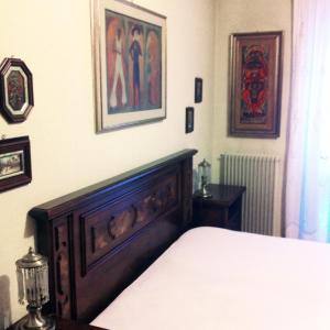 a bedroom with a bed and paintings on the wall at ELDA's Home - Ideale per famiglie in Pinzolo