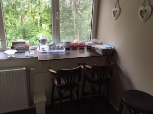 een keuken met 2 stoelen en een aanrecht met een raam bij B & B genieten bij Groen in Drachten