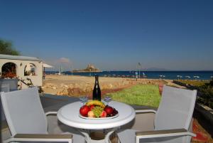 a table with a bottle of wine and a plate of fruit at Kordistos Hotel in Kefalos