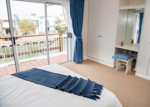 a bedroom with a bed and a large window at Waterfront - home on the Quays in Knysna