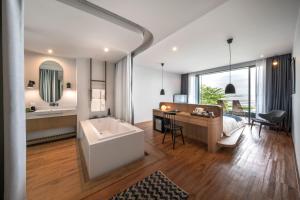 a hotel room with a large tub and a large window at Navana Nature Escape - SHA Extra Plus in Pattaya North