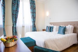 a bedroom with a large bed with blue curtains at Grand Hotel Terme Sirmione in Sirmione