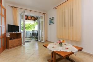 a living room with a table and a television at Apartments Laguna 2 in Bol