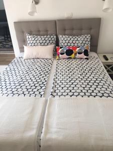 un letto bianco con due cuscini sopra di Apartment Nino a Zara (Zadar)