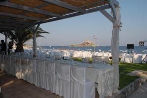 a long table with white table cloths on the beach at Kordistos Hotel in Kefalos