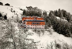 an orange building on a hill with snow on it at Chalet Sourino in Klisoúra