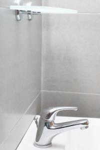 a bathroom with a sink and a chrome faucet at Afroditi Pansion in Agios Nikitas