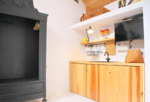 a kitchen with a tv and a wooden cabinet at Senhora do Cabo Meco Homy Holidays in Sesimbra