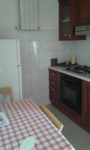 cocina con mesa y fogones horno superior en Casale Fernando, en Borgo Pantano