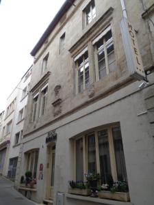 - un bâtiment avec des fenêtres et des fleurs dans une rue dans l'établissement Hotel de Montaulbain, à Verdun-sur-Meuse