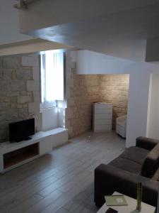 a living room with a couch and a tv at Domus Rosae in Scicli