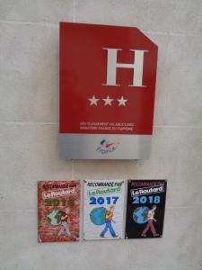 a sign hanging on a wall with two comics at Hotel de Montaulbain in Verdun