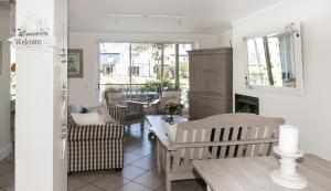 a living room with chairs and a table and a fireplace at Waterfront - 10 Spinniker Knysna Quays in Knysna +31 photos